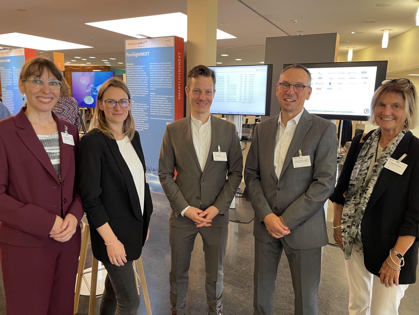 The interdisciplinary SmartLivingNEXT team presented itself in a good mood and well prepared at the stand at the Digital Technologies Days: Dr. Birgit Fröhler, FE at ZVEI, Fanni Vespermann, Materna; Filip Milojkovic, Materna, Andreas Schulz-Dieterich, Materna and Rahild Neuburger, LMU (from left to right). Photo: Maximilian Metzner 